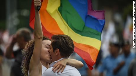 Two women kiss as they take part in the Bucharest Pride 2018 March gay pride parade on June 9, 2018. - The rainbow flag created by artist Gilbert Baker became the symbol of the PRIDE movement 40 years ago, in San Francisco where thousands of people marched on the streets of the city asking respect for lesbians, gays, bisexuals and transgenders. (Photo by Daniel MIHAILESCU / AFP)        (Photo credit should read DANIEL MIHAILESCU/AFP/Getty Images)