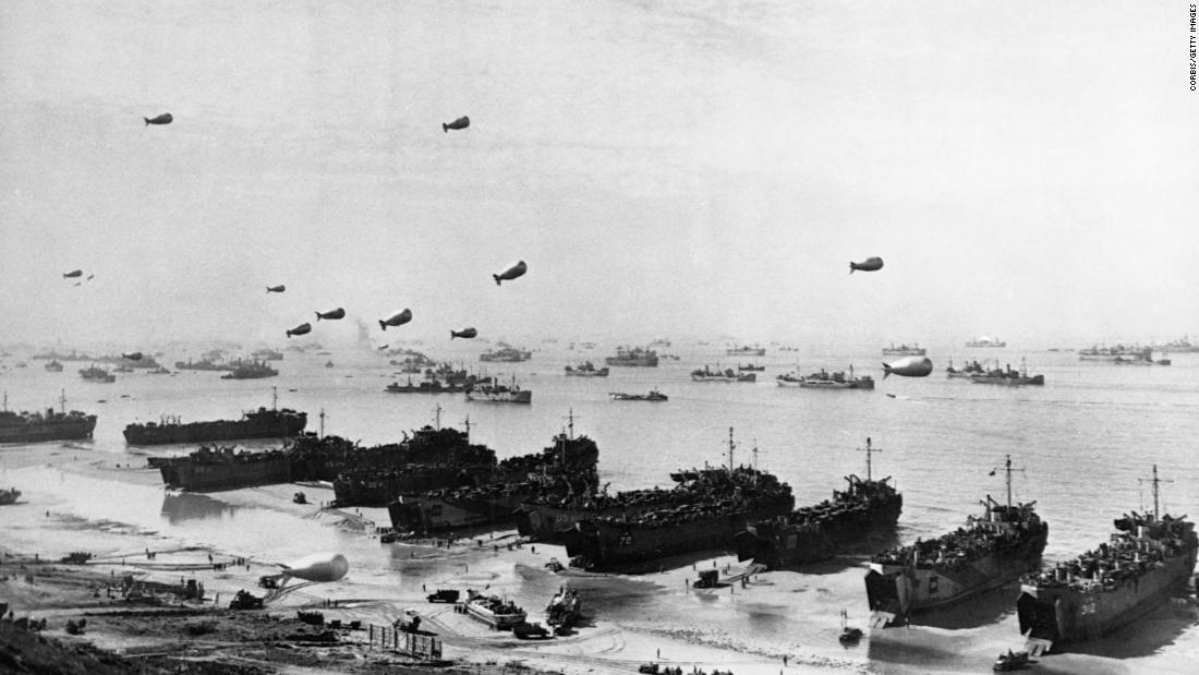Landing craft and a fleet of protection vessels approach Omaha Beach.