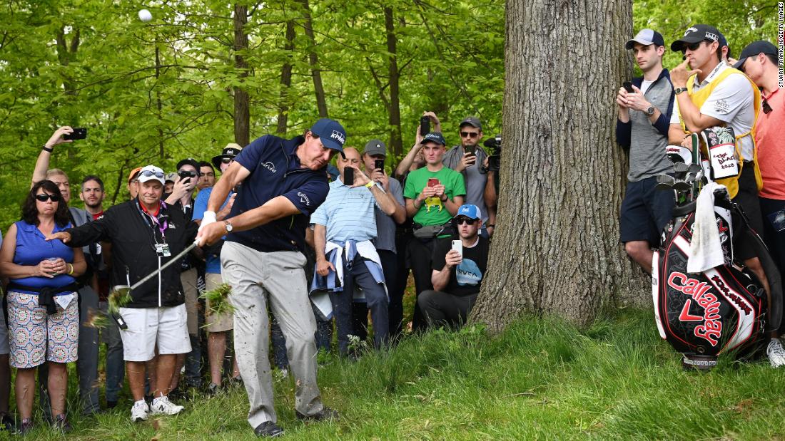 Phil Mickelson plays a shot from the rough on the third hole.