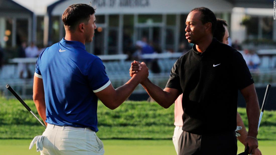 Brooks Koepka, left, shakes hands with Tiger Woods after finishing the second round.