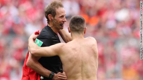 Franck Ribery hugs referee Sascha Stegemann after being shown a yellow card.