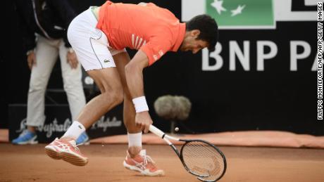 Novak Djokovic smashes his racquet after being broken.
