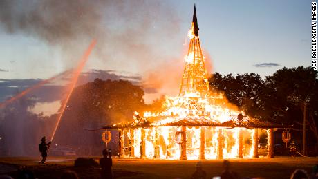 Coral Springs Fire Department firefighters spray water as the Temple of Time burns.