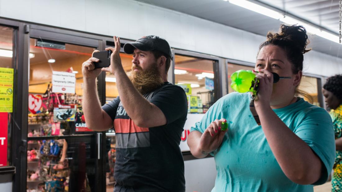 Two people stand outside a gas station in Perry, Oklahoma on Monday, May 20 before a windstorm arrives. Many people took shelter in the gas station.