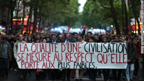 Protesters hold a sign reading &quot;the quality of a civilization is measured by the respect it gives to the weakest&quot; on Monday.