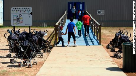 In this August 2018 photo provided by US Immigration and Customs Enforcement, immigrants enter a building at the South Texas Family Residential Center in Dilley, Texas.