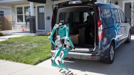 Ford&#39;s robot climbs out of a vehicle to make a delivery.