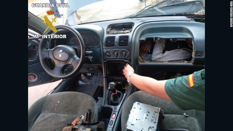 A member of the Spanish Guardia Civil shows the man squeezed into a compartment built behind a car dashboard.