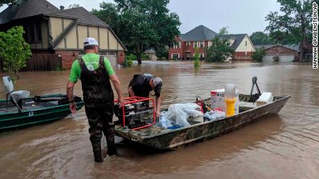 Father and son Brad and Bart Hindley take a boat to Brad&#39;s flooded house in Fort Smith, Arkansas, on Wednesday, May 29, 2019.