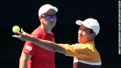 Nishikori serves as Chang looks on during a practice session in Melbourne, Australia in January.