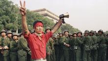 A student pro-democracy protester flashes victory signs to the crowd as People's Liberation Army troops withdraw on the west side of the Great Hall of the People near Tiananmen Square on Saturday, June 3, 1989 in Beijing. (AP Photo/Mark Avery)