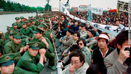 Some of the 200,000 pro-democracy student protesters sit face to face with policemen outside the Great Hall of the People in Tiananmen Square on April 22, 1989. 
