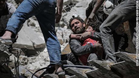 Nour Faham is carried from the rubble of a building destroyed during an airstrike in Ariha on May 27.