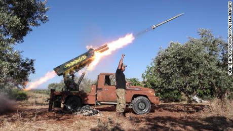 A Syrian fighter from the Turkish-backed National Liberation Front fires a heavy artillery gun from the jihadist-held Idlib province against regime positions in Hama province, on May 26.