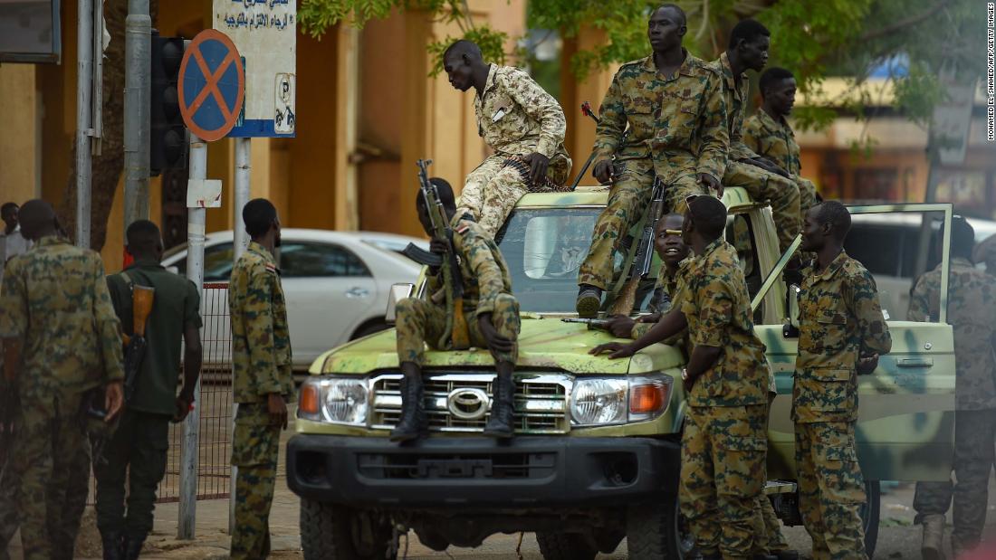 Sudanese army soldiers gather as people rally in front of the Presidential Palace in downtown Khartoum on May 18.