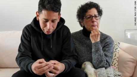 Carlos Jr. and his mother Maria, holding Carla&#39;s favorite sweater, at his home in Brooklyn.