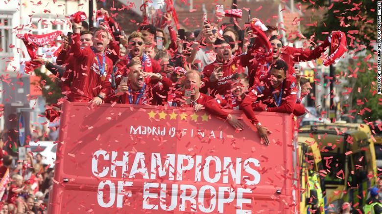 Liverpool players celebrate their Champions League victory surrounded by supporters in Liverpool.