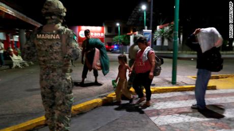 A Mexican marine stands by as camping migrant families are evicted from a park in Tapachula, Mexico, on May 29, 2019. 