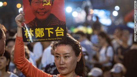 A woman holds a poster of Hong Kong Chief Executive Carrie Lam, against a proposed extradition law, before a candlelight vigil at Victoria Park in Hong Kong on June 4, 2019.