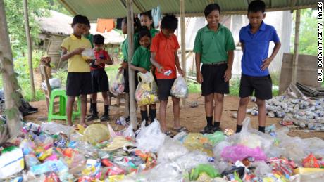 Indian students gather plastic bags before giving them as fees at the Akshar Forum school in Pamohi on the outskirts of Guwahati on May 20, 2019.