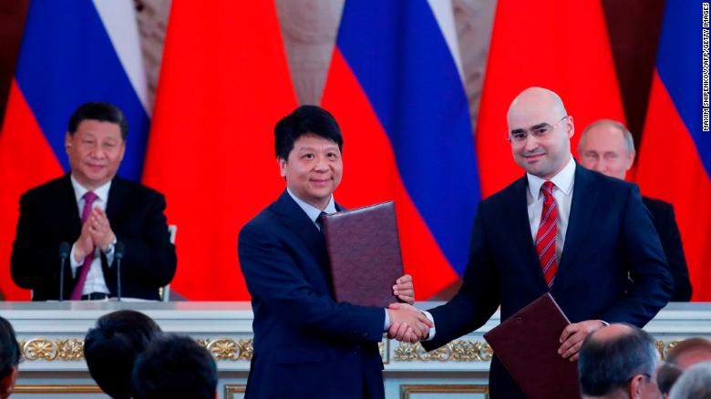 Chinese President Xi Jinping and Russian President Vladimir Putin applaud as Huawei executive Guo Ping shakes hands with Alexei Kornya, President and CEO of Russian mobile phone operator MTS.