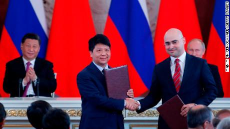 Chinese President Xi Jinping and Russian President Vladimir Putin applaud as Huawei executive Guo Ping shakes hands with Alexei Kornya, President and CEO of Russian mobile phone operator MTS.