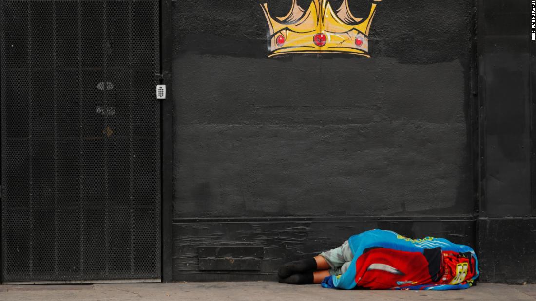 A homeless person sleeps on the sidewalk in Skid Row on June 4.