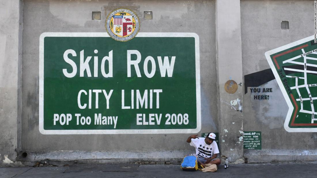 A man gestures while seated beside a Skid Row painting on May 30.