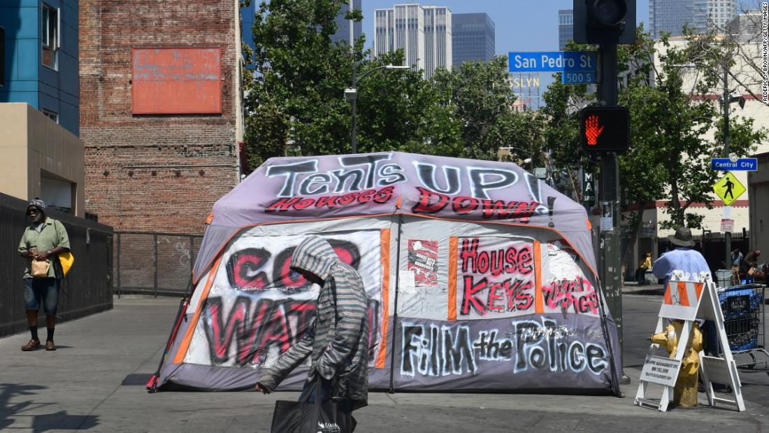 Pedestrians walk past a tent on Skid Row on May 30.