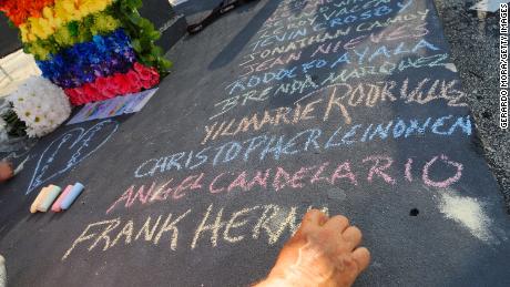 Edwin Rodriguez writes the names of the victims of the Pulse shooting in the front of the nightclub in June 2016 in Orlando, Florida. 