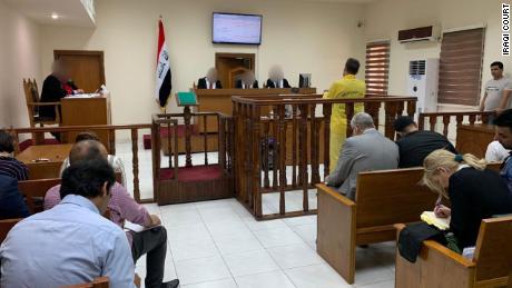 Murad Mohammad Mustafa stands with his back to the camera at the Iraqi court in in Baghdad on Monday, June 3.