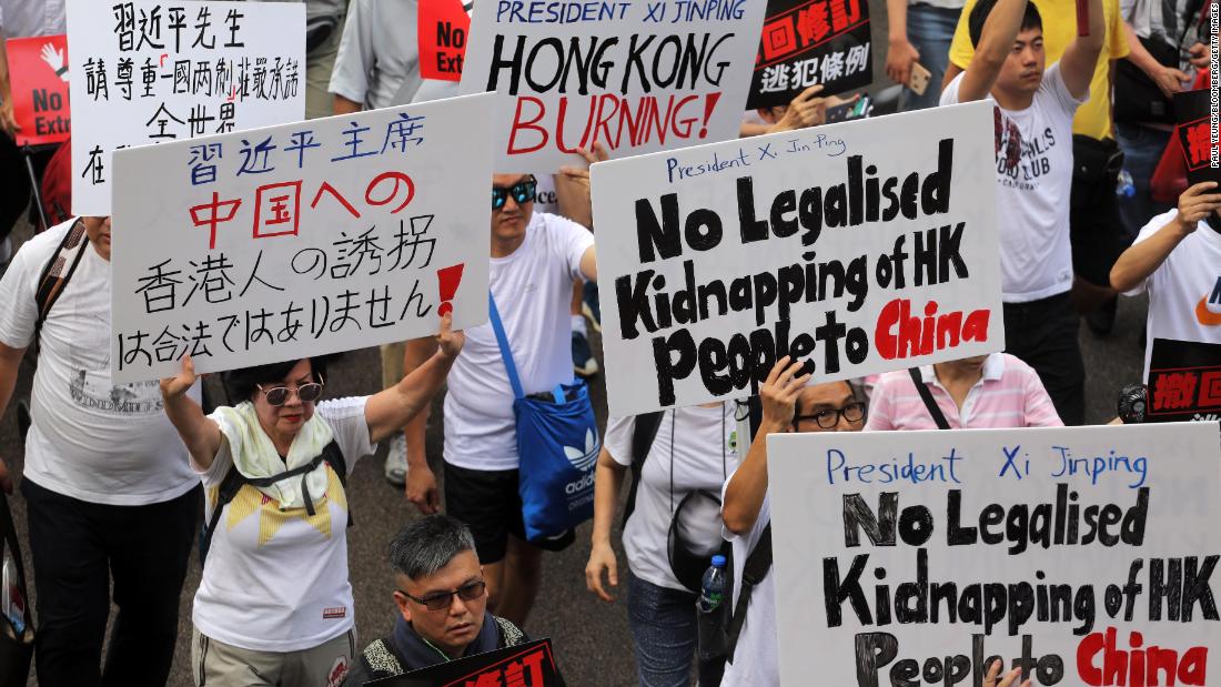 Demonstrators hold signs during the protest on June 9.