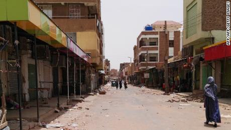 A Sudanese woman walks past closed shops in a commercial street in Khartoum's twin city Omdurman on June 9.