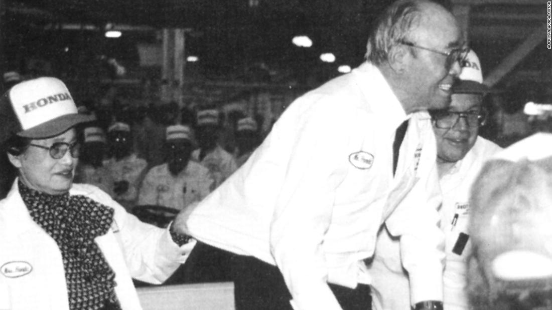 Soichiro Honda&#39;s wife clutches his shirt to prevent him falling while he bows and greets associates at the Marysville plant. 