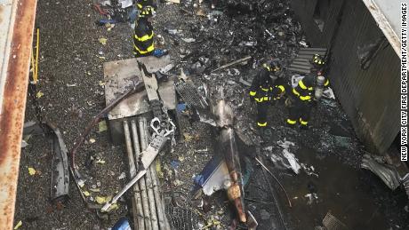 New York City firefighters work at the scene of the helicopter crash Monday.