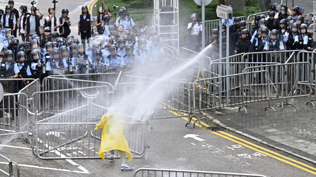 Police officers use a water cannon on a protester near the government headquarters.