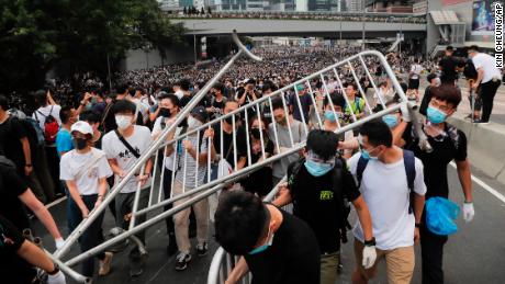 Protesters carry barricades as they march toward the Legislative Council.