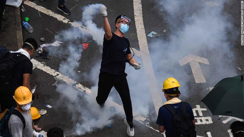 A protester returns a tear-gas canister fired by police during clashes outside the government headquarters in Hong Kong on Wednesday, June 12.