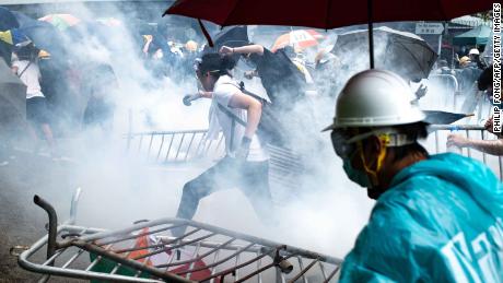 Protesters run after police fired tear gas outside government headquarters on June 12.