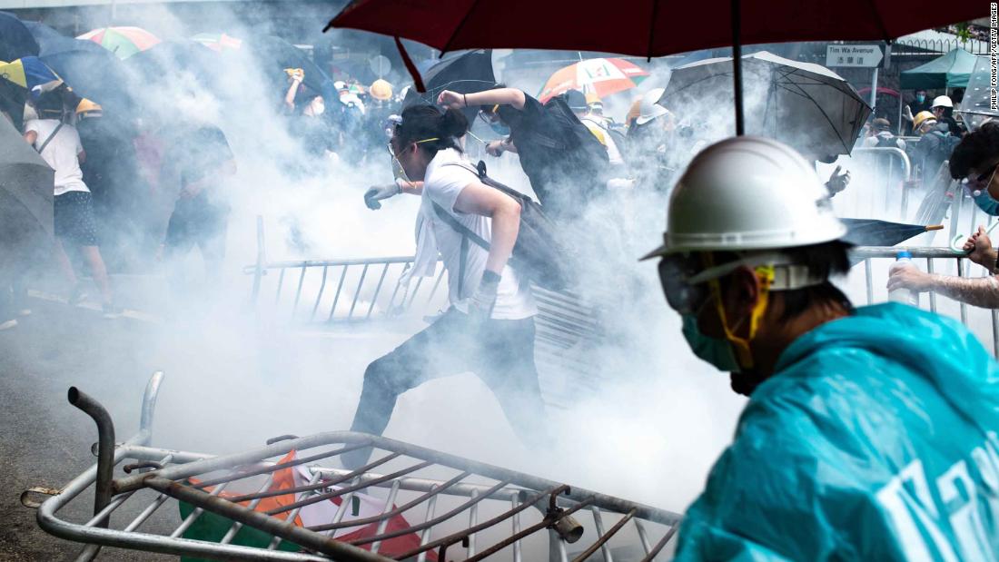 Protesters run after police fired tear gas outside government headquarters on June 12.