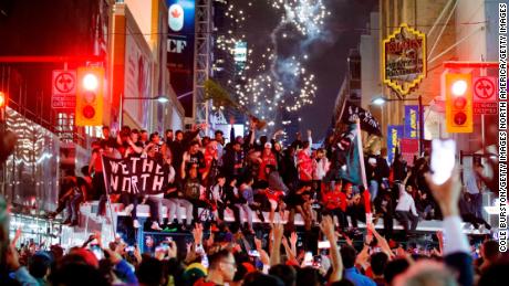 Toronto Raptors fans celebrate atop a bus after the team beat the Golden State Warriors.
