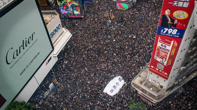 Protesters hold banners and shout slogans as they march on a street on June 16 in Hong Kong.