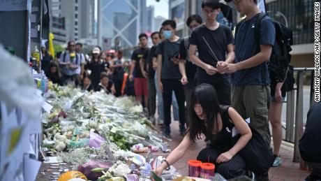 Mourners place flowers and offer prayers at the site where a protester died, prior to the start of a rally in Hong Kong on June 16, 2019. 