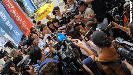 Hong Kong protest icon Joshua Wong is greeted by a scrum of media as he leaves prison on June 17, 2019.