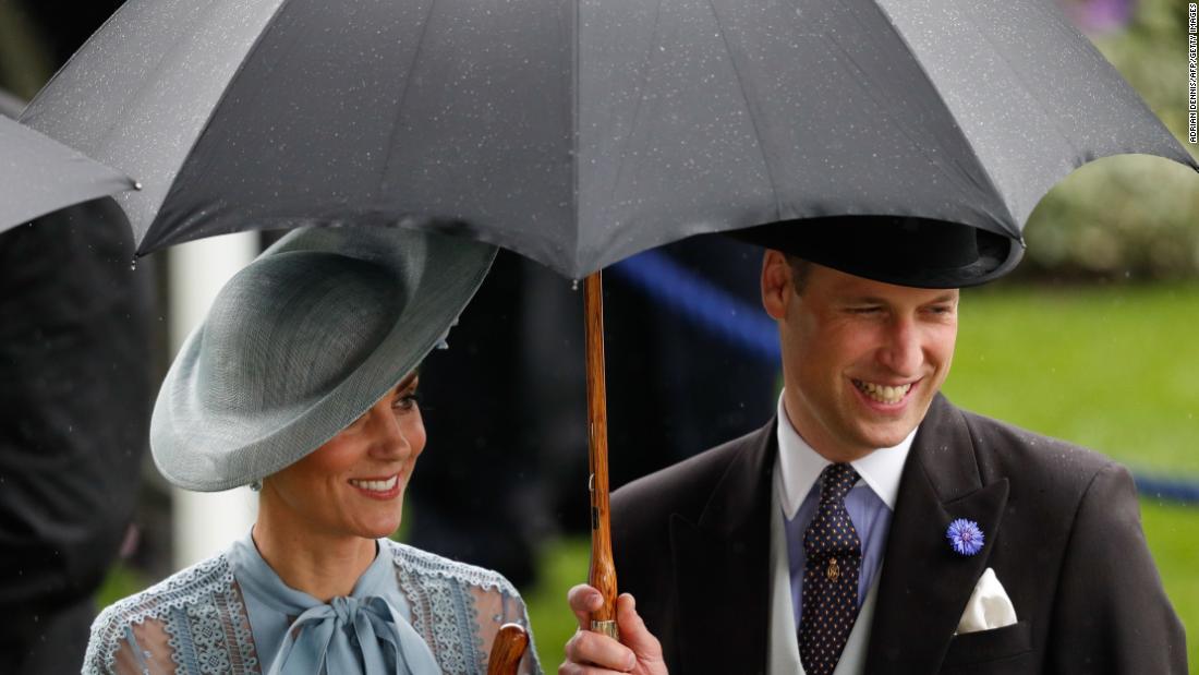 Britain&#39;s Catherine, Duchess of Cambridge and Prince William enjoy the occasion despite the rain. 