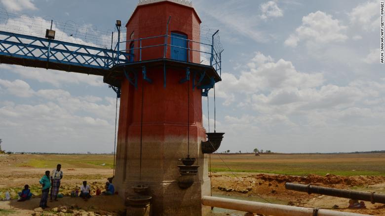 Men sit in the shade of a measuring tower at the dried-out Puzhal reservoir on the outskirts of Chennai on Friday.