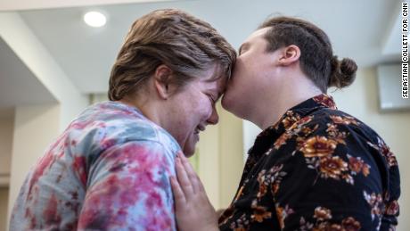 Volunteers Ezra Brown and his fiance Alex Emery embrace before the prom starts.