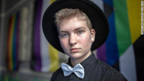 Kirby poses in front of the LGBTQ pride flags hung throughout the fellowship hall.