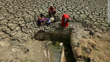 Women fetch water from an opening made by residents at a dried-up lake in Chennai, India, June 11, 2019. 