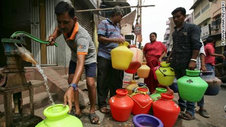 A man uses a hand-pump to fill a container with drinking water as others wait in line in Chennai, India, on June 17, 2019. 